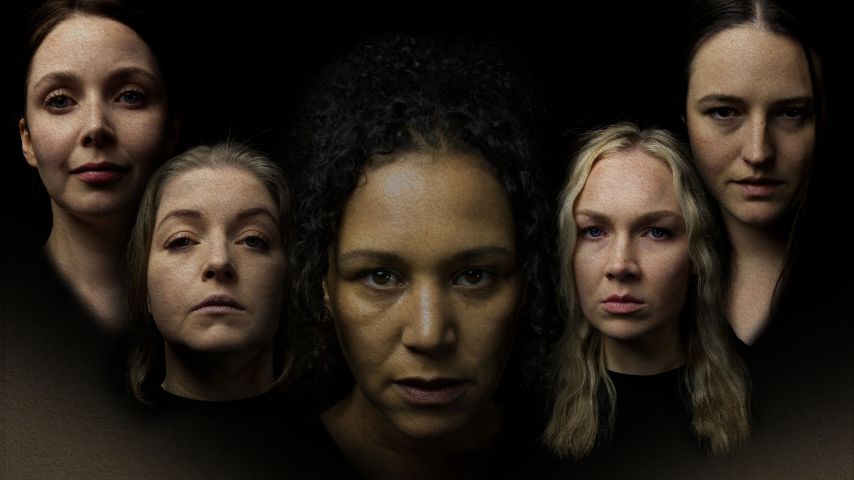 Close up of 5 women, 4 white and one black against a black background