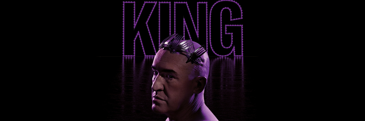 A bald man lit by a purple light, wears a crown made of forks with a large illuminated sign spelling out KING in purple lights is behind him.