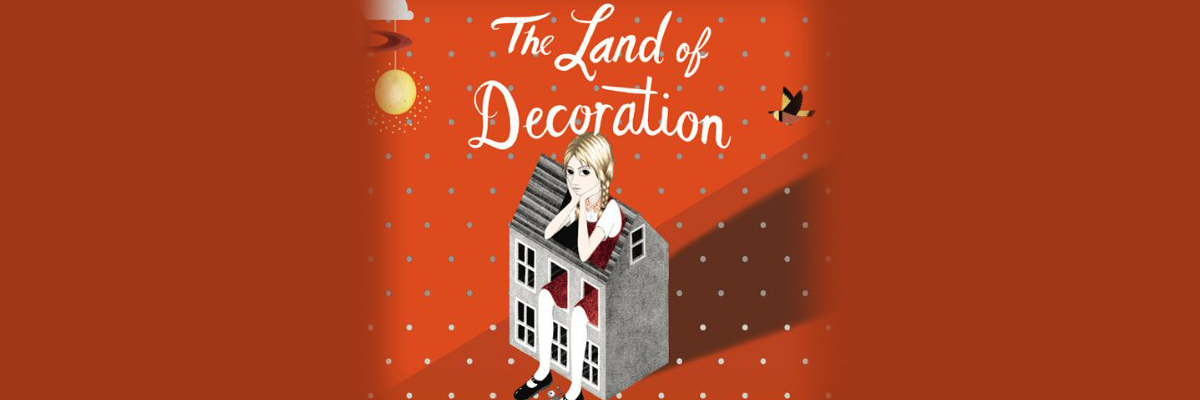 Illustration of a blonde girl with pigtails sitting in a doll house with her legs poking out the top windows. The words 'The Land of Decoration' is in white scripting above her. The background is red with polkadots.
